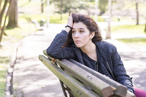 Woman on bench who needs to get rehab info