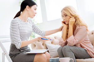 A counselor talks to a woman at a Texas pain management facility